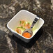 A Front of the House bright white square porcelain bowl filled with food with a spoon.