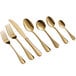 A close-up of several gold Acopa Vernon bouillon spoons.