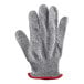 A grey knitted glove with red trim.