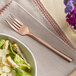 A bowl of salad with a fork next to it.