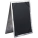 A close-up of a black and silver Menu Solutions Alumitique table tent.