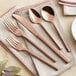 A close-up of a rose gold Acopa Phoenix stainless steel dinner fork on a napkin.