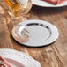 A mirror-finished stainless steel wine coaster or spoon rest on a wooden table.