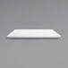 A Front of the House bright white square porcelain plate on a gray surface.