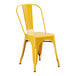 A Lancaster Table & Seating citrine yellow metal outdoor cafe chair with a seat and back.