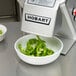 A Hobart continuous feed food processor with a bowl of green peppers.