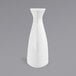 A Front of the House bright white porcelain bud vase on a gray surface.