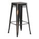 A black metal Lancaster Table & Seating outdoor barstool with a wooden seat.