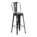 A black metal outdoor cafe barstool with a back.