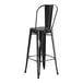 A Lancaster Table & Seating black metal outdoor cafe barstool with a backrest.