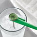 A green AvaTek 5-inch HACCP pocket probe dial thermometer with a calibration wrench, shown in a glass of ice water.