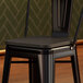 A Lancaster Table & Seating black wood seat for a black metal barstool.