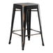 A black metal Lancaster Table & Seating outdoor backless counter height stool with a wooden seat.