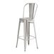 A Lancaster Table & Seating silver metal barstool with a backrest.