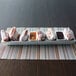 A white rectangular porcelain server holding a plate of donuts and bowls of brown liquid.