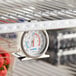 An AvaTemp refrigerator/freezer thermometer on a shelf.
