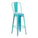 A turquoise metal outdoor barstool with a white seat.