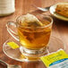 A glass cup of Bigelow Chamomile Mint tea with a tea bag in it.