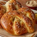 Two soft pretzels on a tray with mustard and butter.