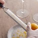 A person using a MercerGrates fine zester to grate a lemon.