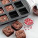 A Wilton bite-size brownie pan with brownies topped with chocolate spread and sprinkles.