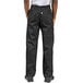 The legs of a man wearing black Uncommon Cargo chef pants.
