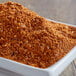 A bowl of Cattlemen's Cowboy BBQ Rub on a wooden table.