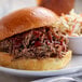 A pulled pork sandwich with coleslaw and a side of Cattlemen's Cowboy BBQ Rub on a plate.
