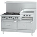 A white Garland commercial range with 6 burners, a raised griddle, and 2 ovens, with black knobs.