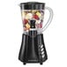 A black Hamilton Beach Wave Station blender with fruit inside.