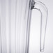 A clear plastic pitcher with a long handle.