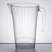 A WNA Comet clear plastic pitcher with a handle.