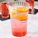 A WNA Comet Classic Crystal pitcher of liquid with orange and lemon slices.