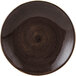 A brown china plate with a dark circle and small black dots.