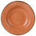 A close-up of a Tuxton TuxTrendz Geode Coral soup bowl with a speckled orange design.