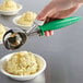 A close-up of a hand using a Hamilton Beach Green Thumb scoop to dish food.