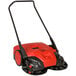 A red and black Bissell Commercial outdoor power sweeper with wheels.