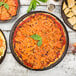 A Tablecraft Lunara brown melamine platter holding a variety of pizzas on a table.