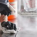 A gloved hand using an Advantage Chemicals spray bottle to clean a surface.
