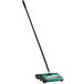 A green and black Bissell Commercial floor sweeper.