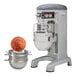 A Hobart floor pizza mixer with standard accessories and a large bowl with a coin in the middle.