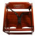 A wooden high chair with a black strap.