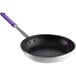 A black frying pan with a purple silicone handle.