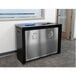 An Ex-Cell Kaiser black and silver metal rectangular two-stream recycling receptacle with a recycle symbol on it.