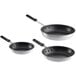 A close-up of a black Choice 3-piece aluminum frying pan with a black handle.