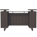 A Safco Mirella reception desk in Southern Tobacco wood with a glass countertop and black metal legs.