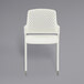 a white plastic chair with a perforated back