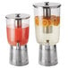 Two American Metalcraft stainless steel juice dispenser bases holding glass beverage dispensers with oranges and lemons.