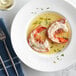 A white plate with a cooked Boston Lobster Company 6-7 oz. lobster tail.