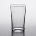 A clear Duralex glass tumbler on a white surface.